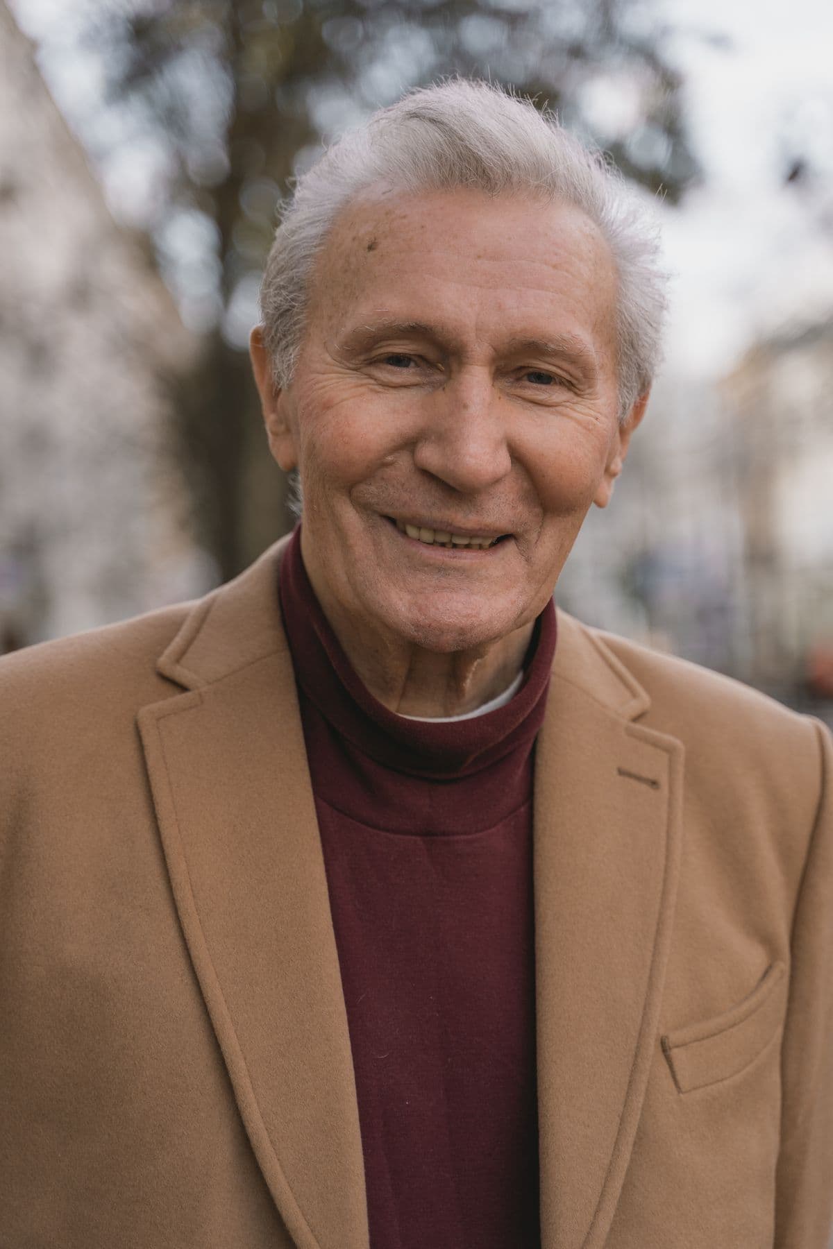 Homme d’âge mûr en manteau beige, à l’extérieur