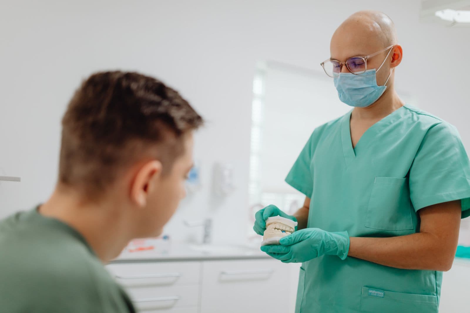 Chirurgien en tenue de bloc s’entretenant avec un patient